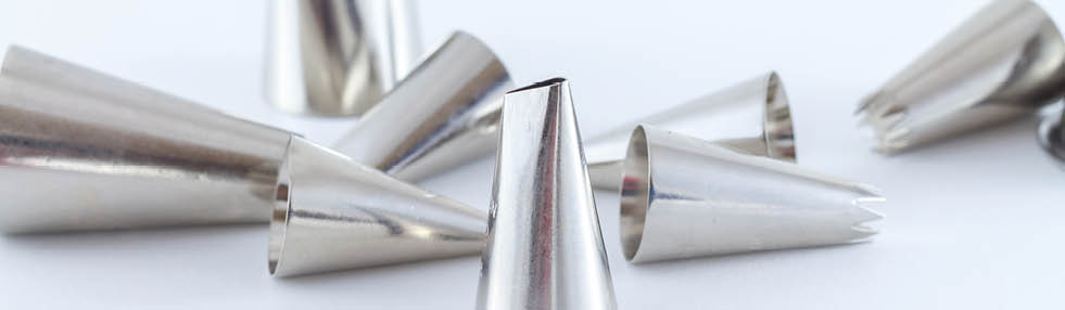 Various metal icing tips for decorating cakes and cookies with frosting isolated on white background