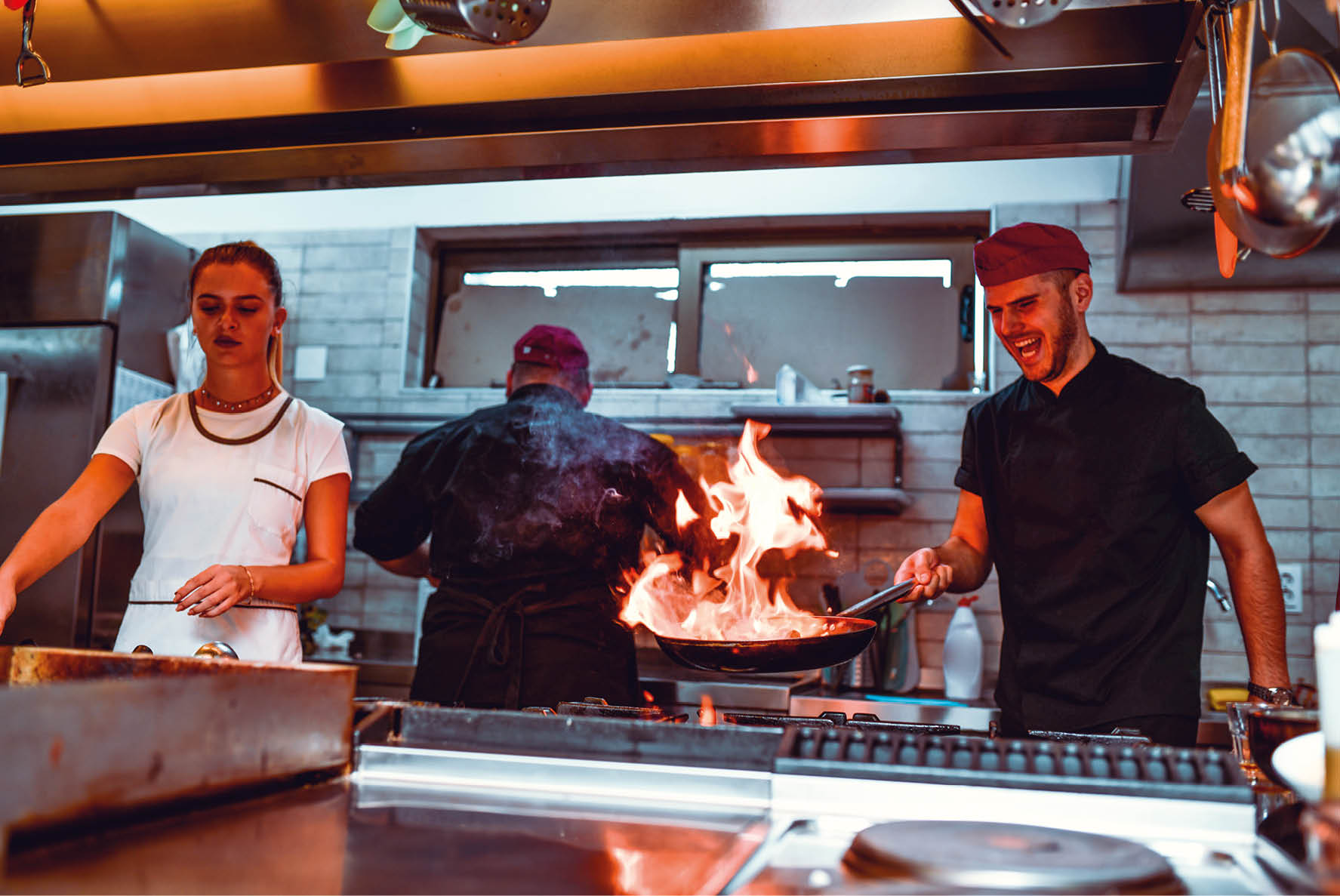 Male Chef Trying Out Oriental Flaming Recipe In Professional Kitchen