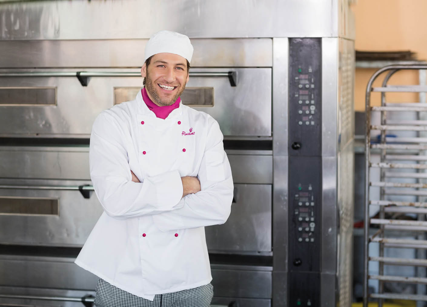 Smiling baker looking at camera in the kitchen of the bakery