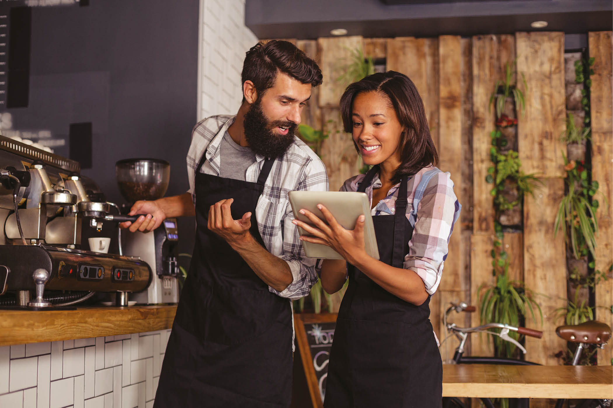 Waiter and waitresses using laptop while working in caf
