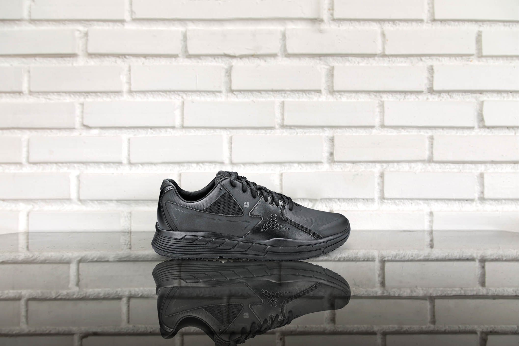 white cup of hot coffee on top of glass table with white brick wall background. concept fot drink and food