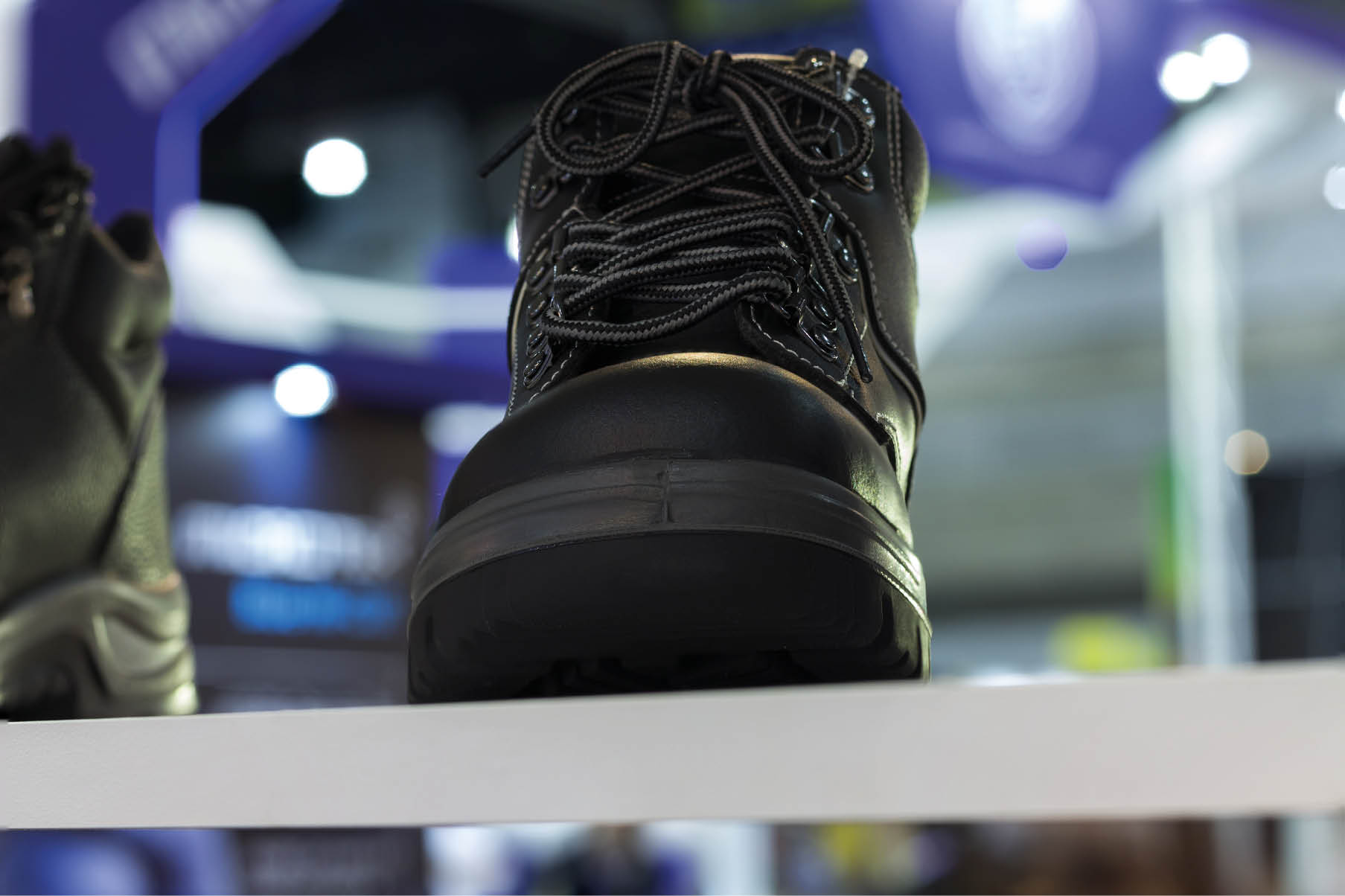 Safety Shoe is a durable boot or shoe that has a protective reinforcement in the toe which protects the foot from falling objects or compression. industrial background