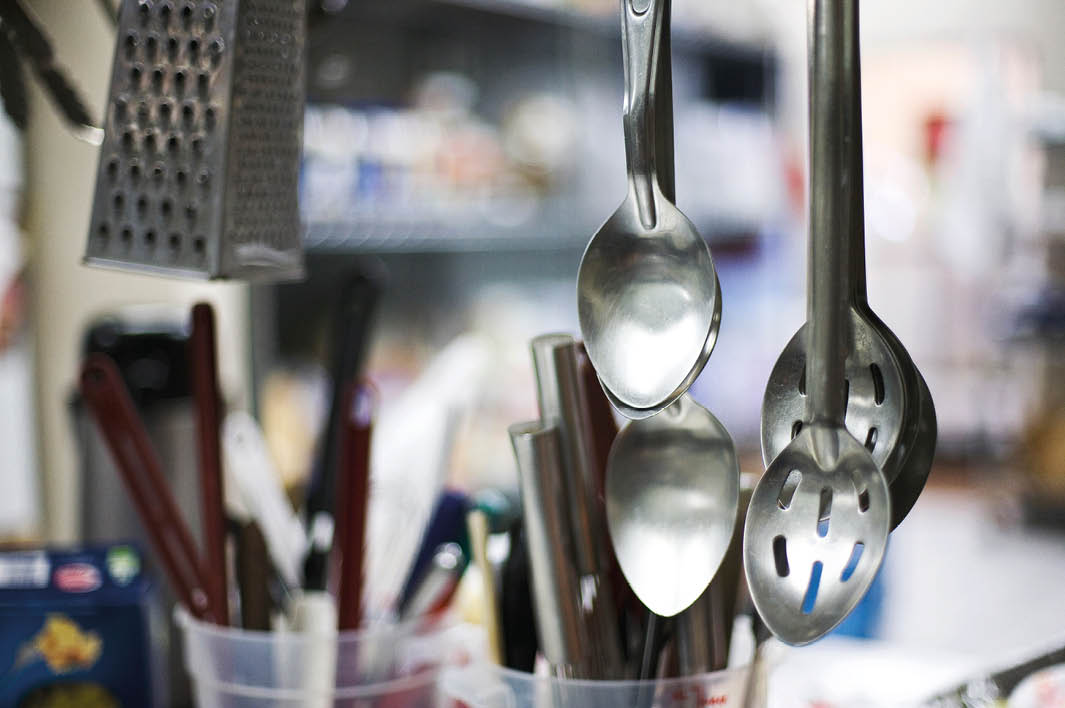 Cooking spoons hanging in commercial kitchen