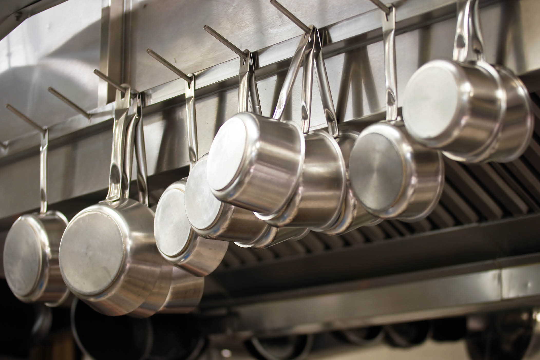 Many pans hanging in a restaurant kitchen